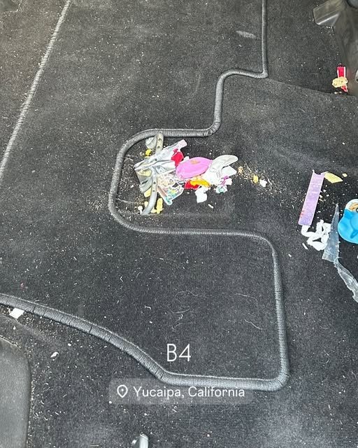 Floor mat with candy wrappers and crumbs before cleaning