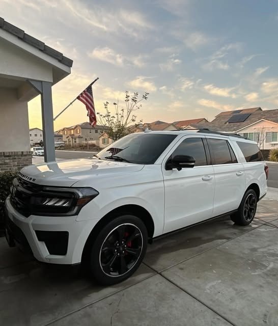 White Ford Expedition with black wheels after a detail