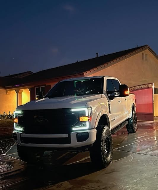 White Ford F-150 detailed at dusk with headlights on