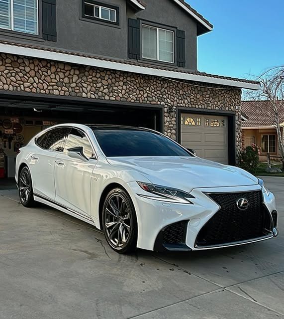 White Lexus LS detailed and parked in front of a garage